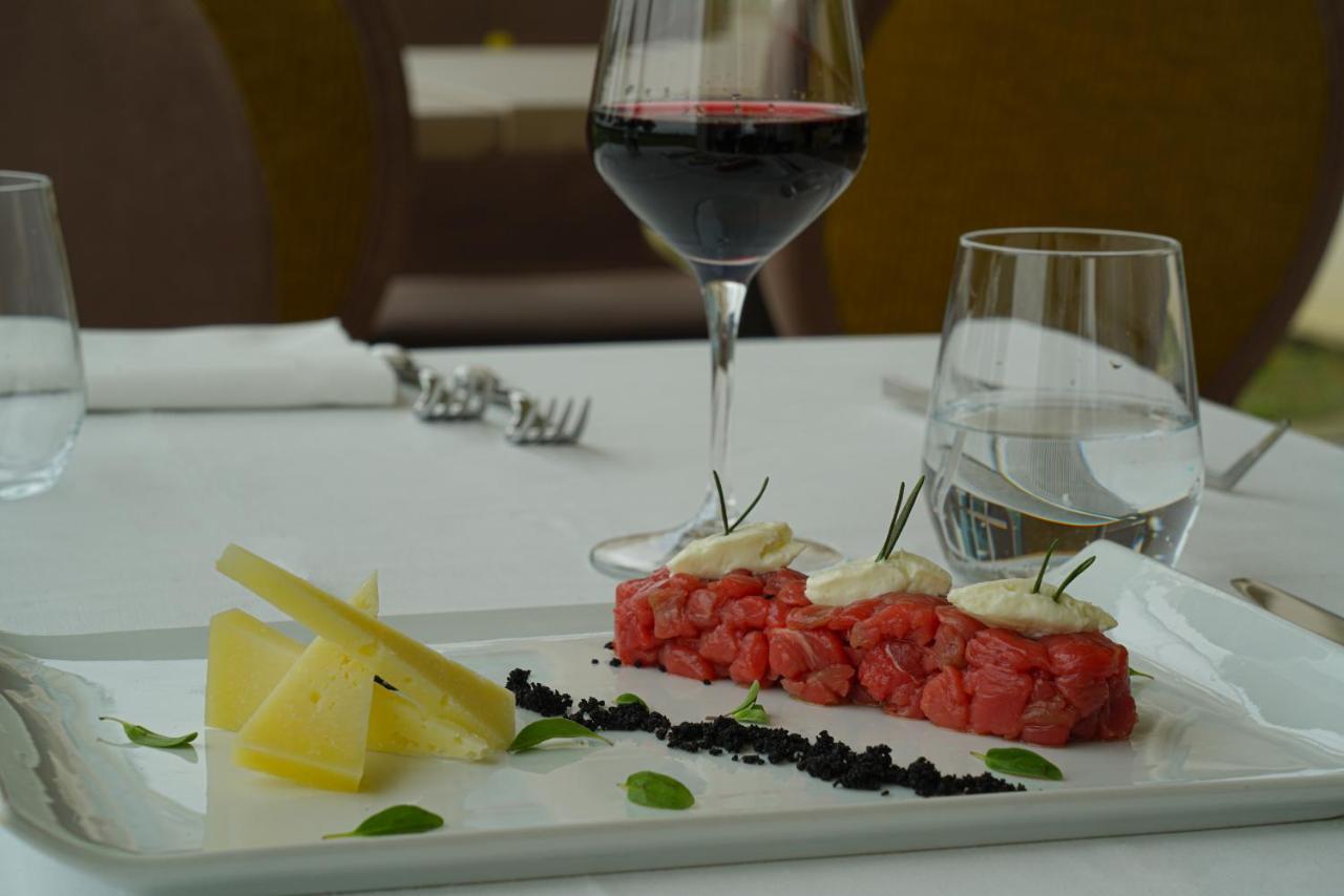 Pisa Tower Plaza Hotel Luaran gambar A glass of red wine with a plate of tartar